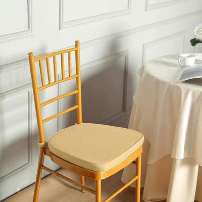 Gold chiavari chair with cushion in elegant dining setting.