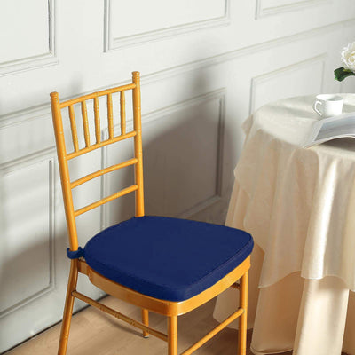 Navy blue chair cushion on a wooden chair in a styled setting.
