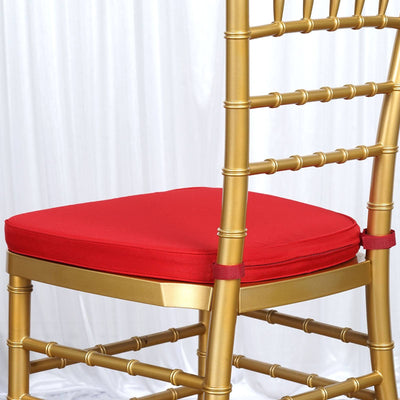 Gold chiavari chair with red cushion, ideal for events and weddings.