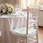 Elegant wedding table setting with floral centerpiece and cushioned chiavari chair