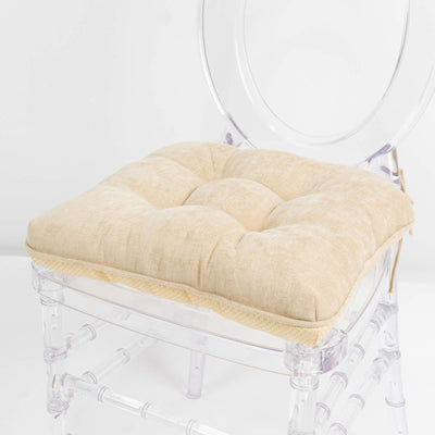 Cream tufted chair cushion on clear acrylic chair, close-up
