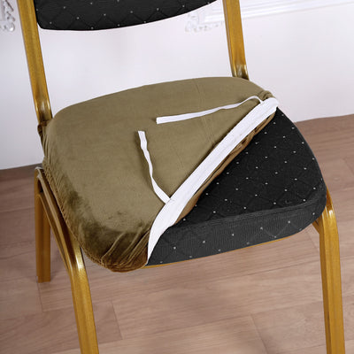Green velvet chair cushion with ties on a patterned chair.