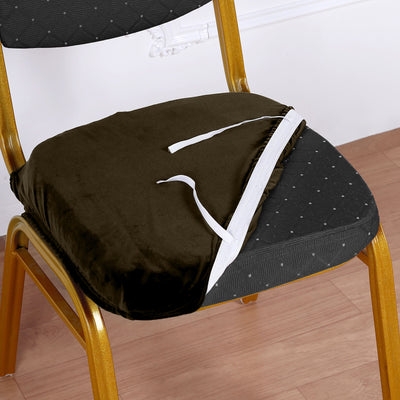 Brown velvet chair cushion with ties on a wooden chair.