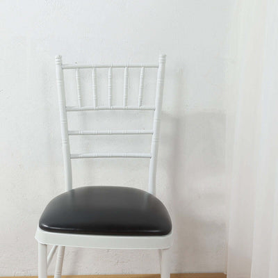 White Chiavari chair with black seat on plain backdrop