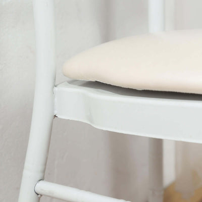 Close-up of a white chair with a padded seat.