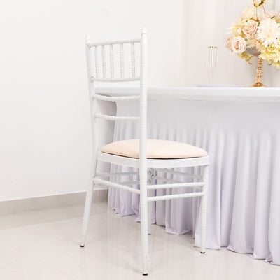 White chiavari chair with cream cushion against a plain backdrop.
