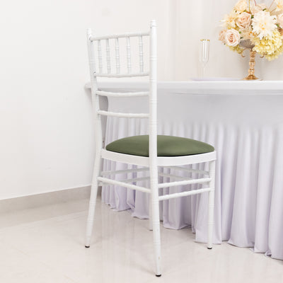 White chiavari chair with green cushion in a minimalist setting.