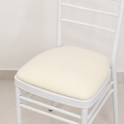 White chair with a cream cushion on a plain background.