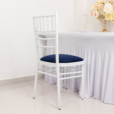 White chiavari chair with navy cushion beside a table with floral arrangement.