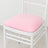White chair with pink cushion on a plain background.