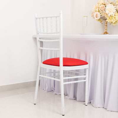 White chiavari chair with red cushion against a table.