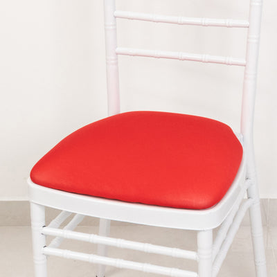 White chair with red cushion on a plain background.