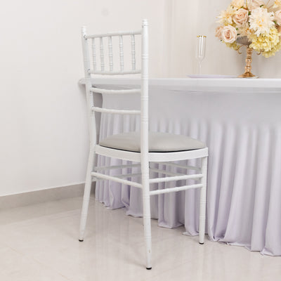 White chiavari chair with a cushioned seat against a plain backdrop.