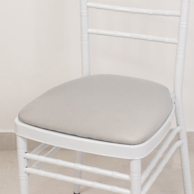 White chiavari chair with gray cushion on a plain background.