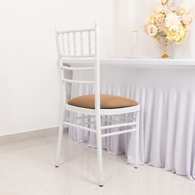 White chiavari chair with brown cushion in a decorated setting.