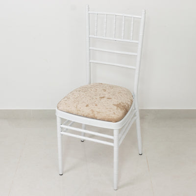 White chiavari chair with beige cushion on a plain background.