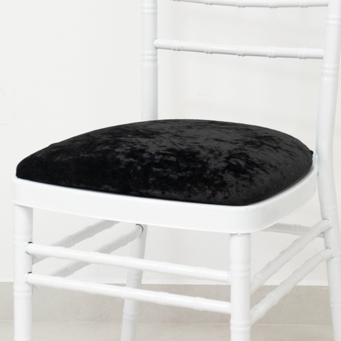 Black velvet chair cushion on a white chair