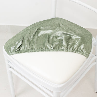 Green velvet chair cushion cover on a white chair.