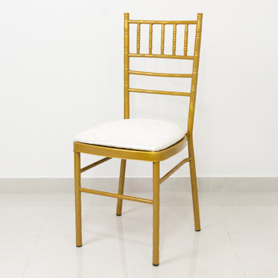 Gold chiavari chair with white cushion on plain background