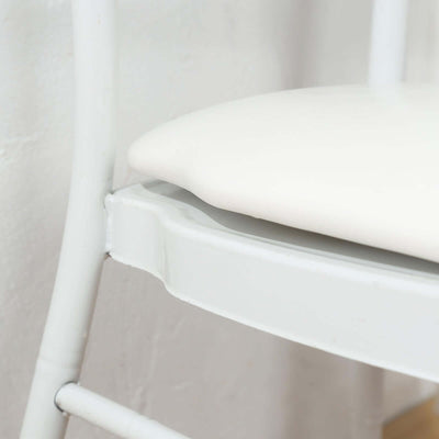 Close-up of a white chair seat and frame, highlighting smooth curves and design details.