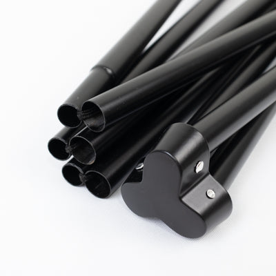 Black tent poles with heart-shaped connector, arranged in a bundle.