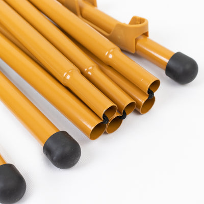 Set of yellow tent poles with black rubber tips on a white background.