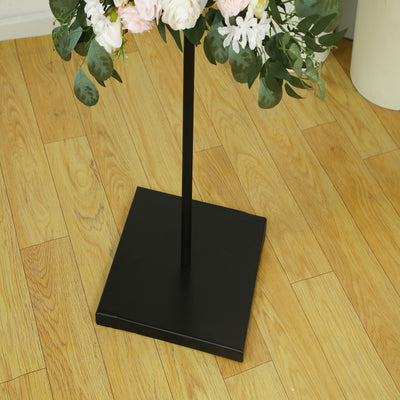 Black metal flower stand base with decorative floral arrangement.
