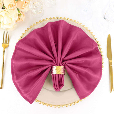 Elegant burgundy napkin elegantly arranged on a gold charger plate.