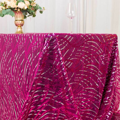 Shiny fuchsia tablecloth draped elegantly on a table with floral arrangement.