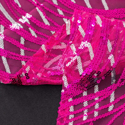 Fuchsia sequin fabric with intricate patterns and textures.