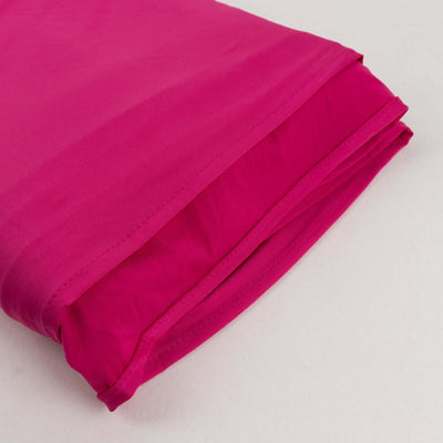 Folded magenta fabric showcasing smooth texture and vibrant color.