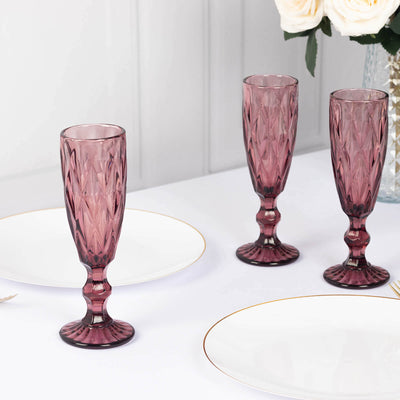 Set of three elegant pink vintage glass flutes on a dining table.