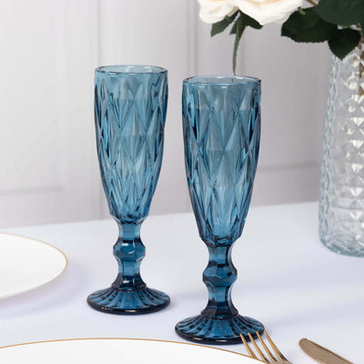 Set of two elegant blue crystal champagne flutes on a dining table.