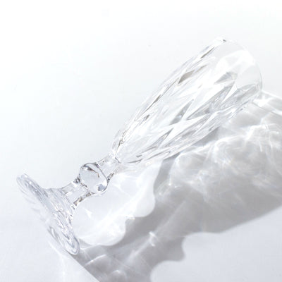 Crystal champagne flute on a plain background, showcasing elegant cut design.