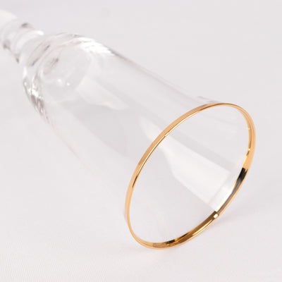 Elegant glass champagne flute with a gold rim.