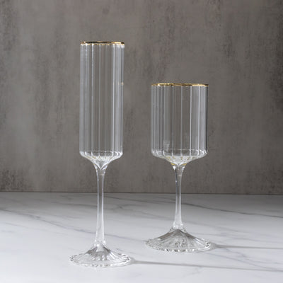 Elegant glass flutes with gold accents on a marble surface.