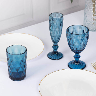 Blue glassware set on a dining table with white plates.