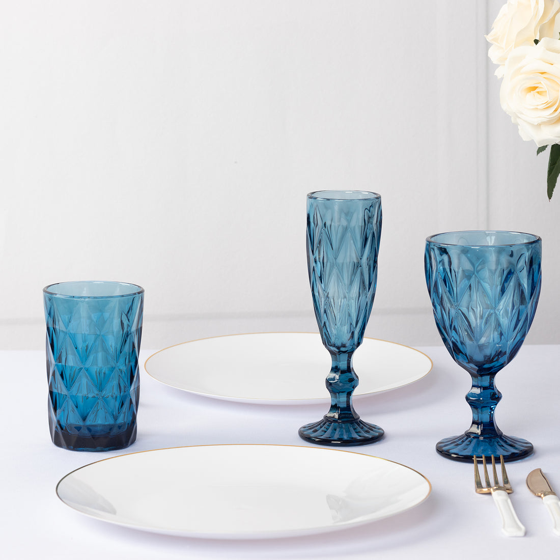 Blue glassware set with white plates on a table
