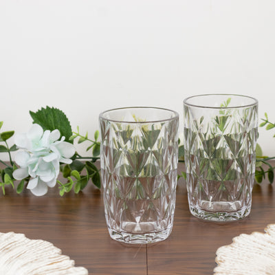Set of two crystal clear glasses with a diamond pattern on a wooden table.