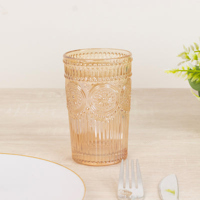 Decorative pink glass tumbler on a table with cutlery.