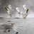 Elegant glass martini glasses with olives on a textured surface.