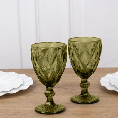 Green textured glass goblets on a wooden table.