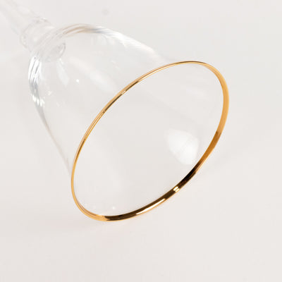Gold-rimmed glass cup on plain background