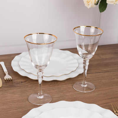 Elegant glassware with gold rims on a wooden table setting.