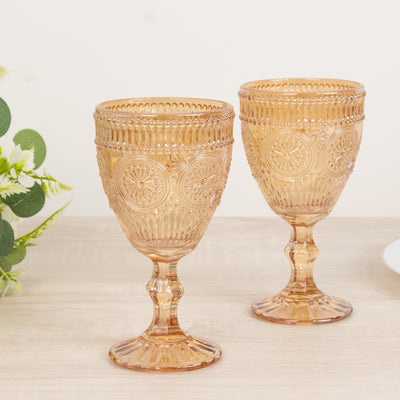 Two vintage amber glass goblets on a wooden table.