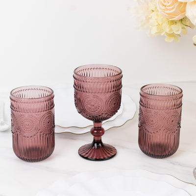 Set of three elegant purple glassware pieces on a marble surface.
