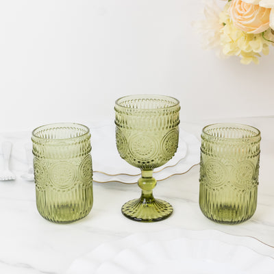 Green glass drinkware set with textured design on a marble surface.