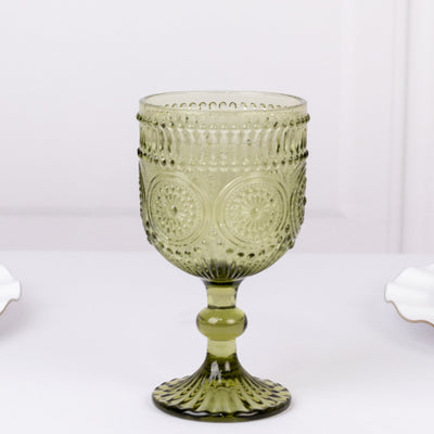 Green embossed glass goblet on a plain background.