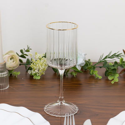Elegant glass goblet with gold rim on a wooden table.