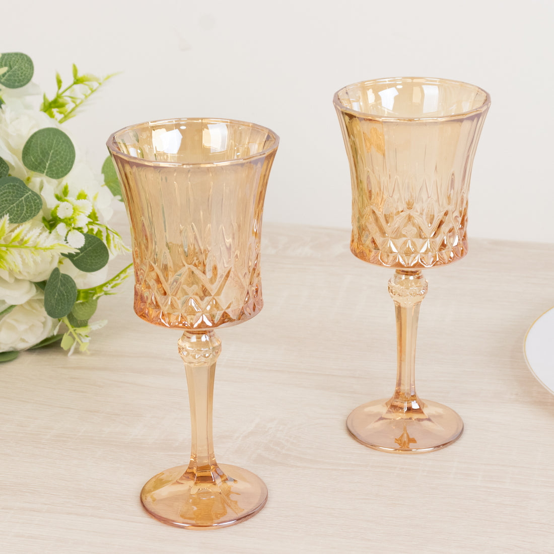 Elegant set of two amber glass goblets on a wooden table.